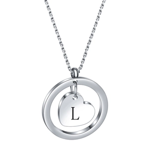 Detail of a stainless steel necklace with round frame and heart pendant engraved with letter L