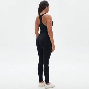 Macro shot of seamless black yoga jumpsuit featuring a cross back design and high-stretch fabric