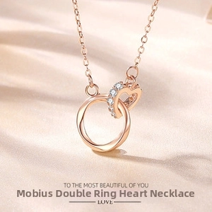 Detail of rose gold Mobius heart necklace with pave set crystals on silk background