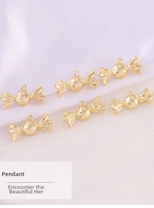 Detail of six gold plated candy shaped metal pendants with white zircon on silk fabric