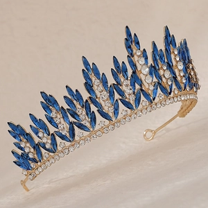 Close-up of luxury bridal crown with marquise blue rhinestones and gold leaf details