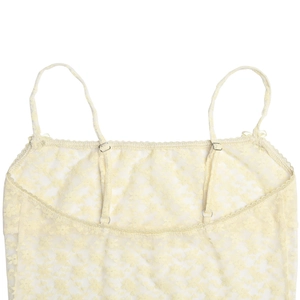 Detailed close-up of yellow floral lace dress featuring thin adjustable metal buckles