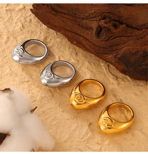 Detailed close-up of textured gold and silver rings with eye and lip relief designs