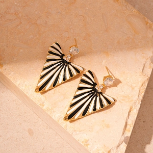 Macro detail of striped enamel triangle earrings with inlaid zircon and gold plating