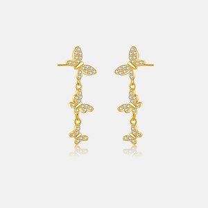 Detailed close-up of golden butterfly tassel earrings with sparkling cubic zirconia stones