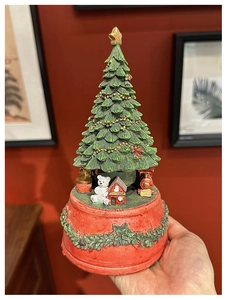 Macro detail of Christmas tree music box with miniature bear and vintage train on base