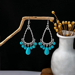 Bohemian dangle earrings with turquoise beads and silver metal on natural branch