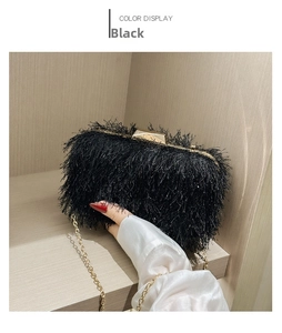 Macro view of black tassel clutch bag featuring gold hardware and delicate chain strap