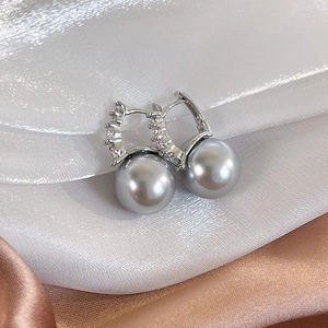French luxury silver earrings with gray pearls and sparkling zircons on silk fabric