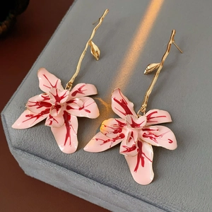 Detail view of vintage branch style earrings with pink and red floral drip oil pendants