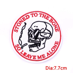 Detail view of a 7.7cm circular skeleton embroidery patch with red stitched text