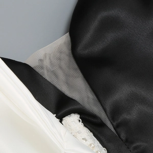 Détails de satin noir avec plis blancs et dentelle ornée de perles élégantes