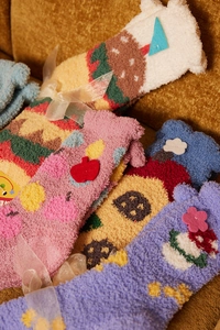 Detailed view of colorful coral fleece socks with 3D embroidery and gift ribbon packaging