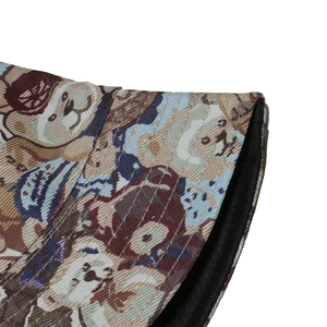 Close-up of thick woven sun hat with retro teddy bear pattern and stitched brim detail