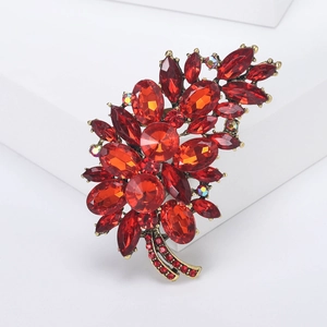 Macro shot of gold-plated alloy brooch with radiant red rhinestones and marquise crystals