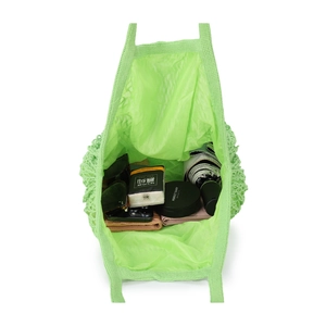 Detailed top view of grass green crochet tote bag filled with daily essentials for summer