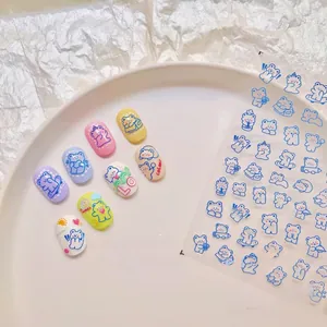 Detail of 5D embossed nail art stickers with blue cartoon bears on macaron color tips