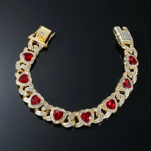Hip hop style gold bracelet with red heart gems and sparkling rhinestones on black background