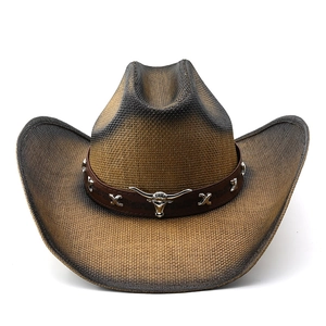 Detail of brown cowboy hat featuring a silver bull head ornament and leather band studs