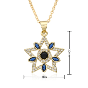 Macro detail of gold-tone star pendant featuring blue marquise and black round zircons