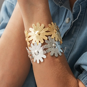 Détail d'un bracelet manchette floral bicolore or et argent sur chemise bleue
