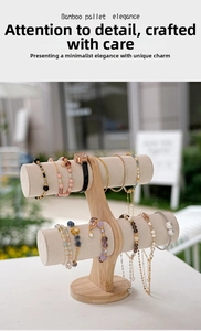 Detailed view of bamboo jewelry stand with gray velvet bars and round stable base