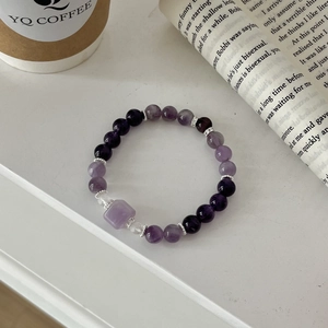Detailed macro view of purple amethyst beads and silver spacers on a vintage book