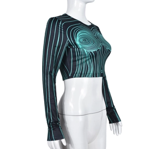Détail d'un crop top à manches longues avec motifs de vagues vertes sur fond noir poli