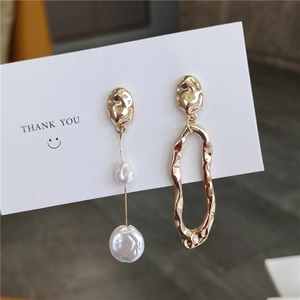 Asymmetric gold baroque pearl earrings with irregular metal geometric shapes on card