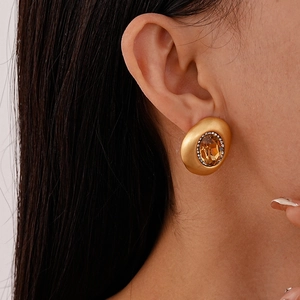 Detailansicht goldene Vintage-Ohrstecker mit bernsteinfarbenem Stein und Kristallbesatz