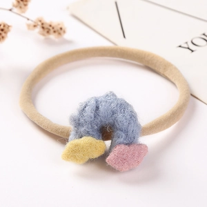 Détail d'un arc-en-ciel en peluche sur un bandeau pour bébé en nylon souple