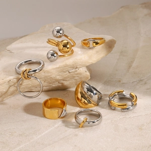Close-up of modern two-tone stainless steel rings displayed on natural textured stone