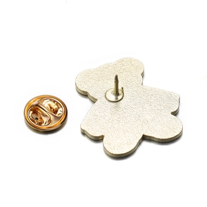 Detail view of gold-colored bear brooch back with textured metal and butterfly clutch