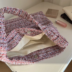 Gros plan de l'intérieur du sac en tweed rose avec fermoir magnétique et doublure douce