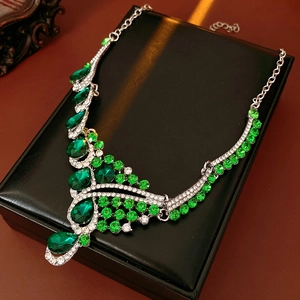 Close-up of vintage emerald teardrop necklace with shimmering crystals in a black gift box