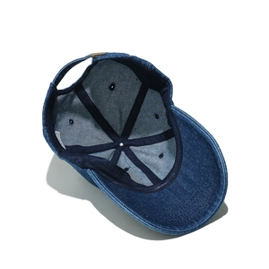 Detailed interior of navy denim baseball cap showing adjustable buckle and sweatband