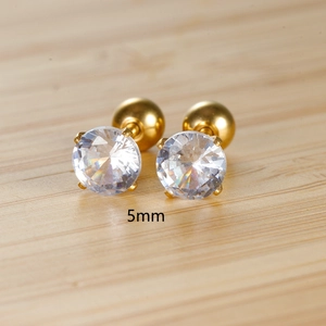 Detail of 5mm clear zircon earrings with golden screw back on wood background
