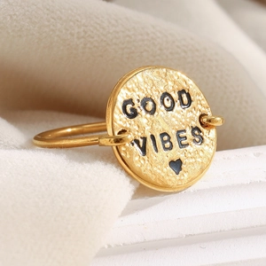Detailed macro view of 18K gold plated ring featuring a GOOD VIBES engraved round charm