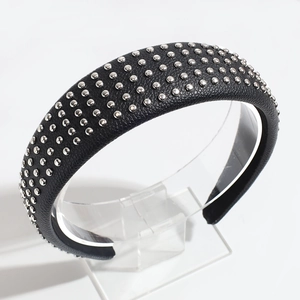 Close-up of black PU leather headband with silver round metal rivets on a display stand