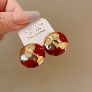 Close-up of S925 silver red and gold enamel earrings with a geometric wavy design