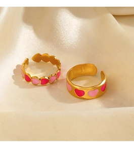 Dettaglio di anelli a cuore in smalto rosa con placcatura oro 18K su sfondo satinato