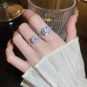 Close-up of sparkling zircon geometric silver rings worn by model with elegant styling