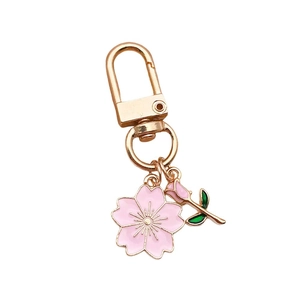 Detailed view of pink cherry blossom alloy pendant with golden keychain ring and clip