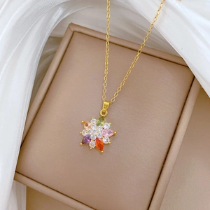 Close-up of a luxury gold titanium necklace with a colorful crystal flower pendant