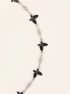 Detail of silver chain belt featuring black butterfly pendants and sparkling rhinestones