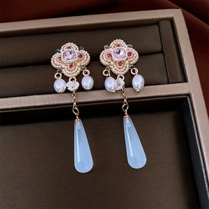 Close-up of vintage flower resin earrings with pink gemstones and blue chalcedony drops