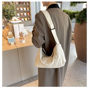 Quilted corduroy tote bag in off-white shown on model in a cozy bookstore setting