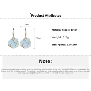 Detail view of white flower drop earrings with copper zircon and gold-plated hooks
