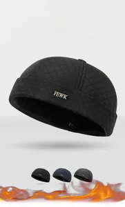 Close-up of quilted diamond pattern and golden FEWK metal logo on black miki hat