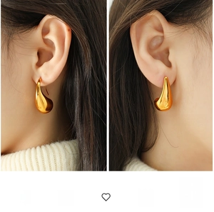 Macro detail of large gold teardrop earrings with high-shine mirror polished finish